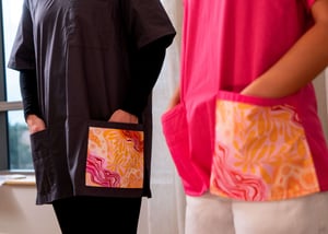 E4 female and male scrubs pink and grey colour with aborignal art work hands in pocket