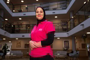 E4 nurse hands clasped smiling to camera side on