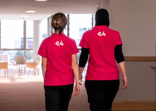 E4 nurses talking to eachother walking down a corridor backs to camers