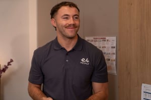 Male E4 nurse in grey uniform smiling looking away from camera