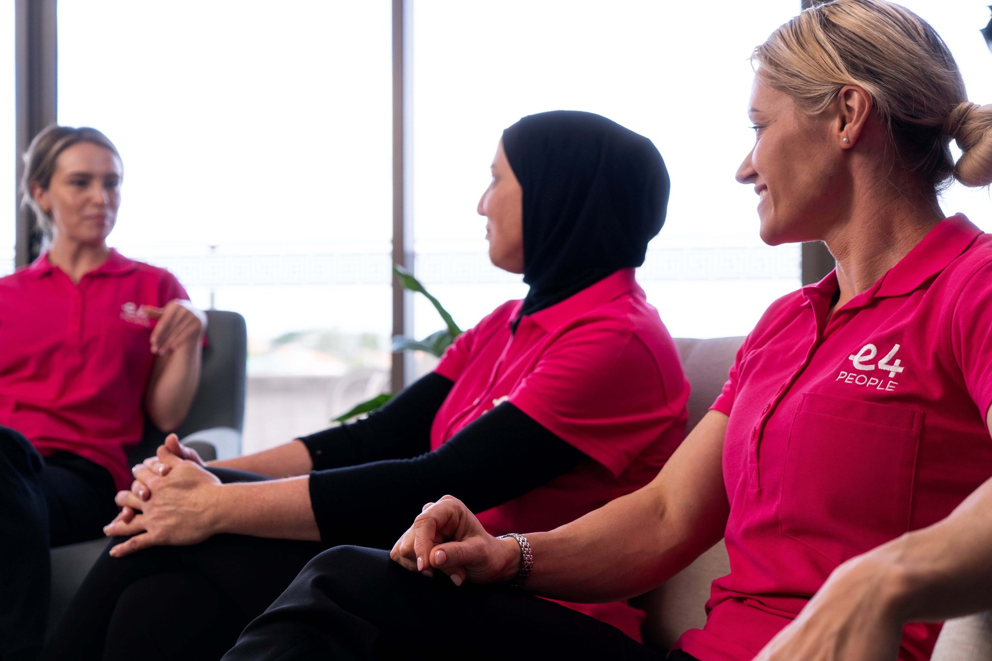 Three E4 nurses sat talking to eachother Three E4 nurses sat talking to eachother