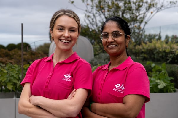 Two E4 nurses in pink uniform folded arms and smiling to camera 3
