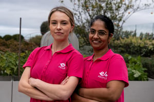 Two E4 nurses in pink uniform folded arms and smiling to camera 5