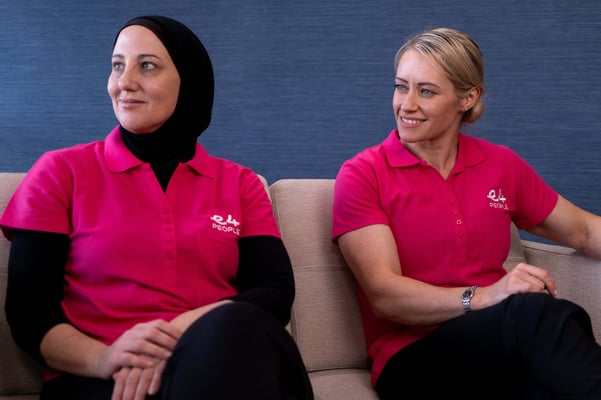 Two E4 nurses talking on a sofa smiling