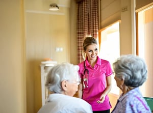 a nurse wearing pink polo talking to a resident in an aged care bedroom documentary style and warm-3-1